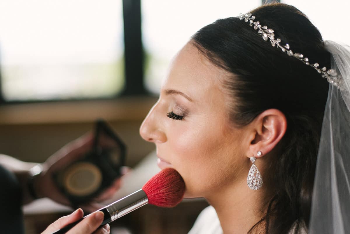 make up being put on bride by professional before wedding