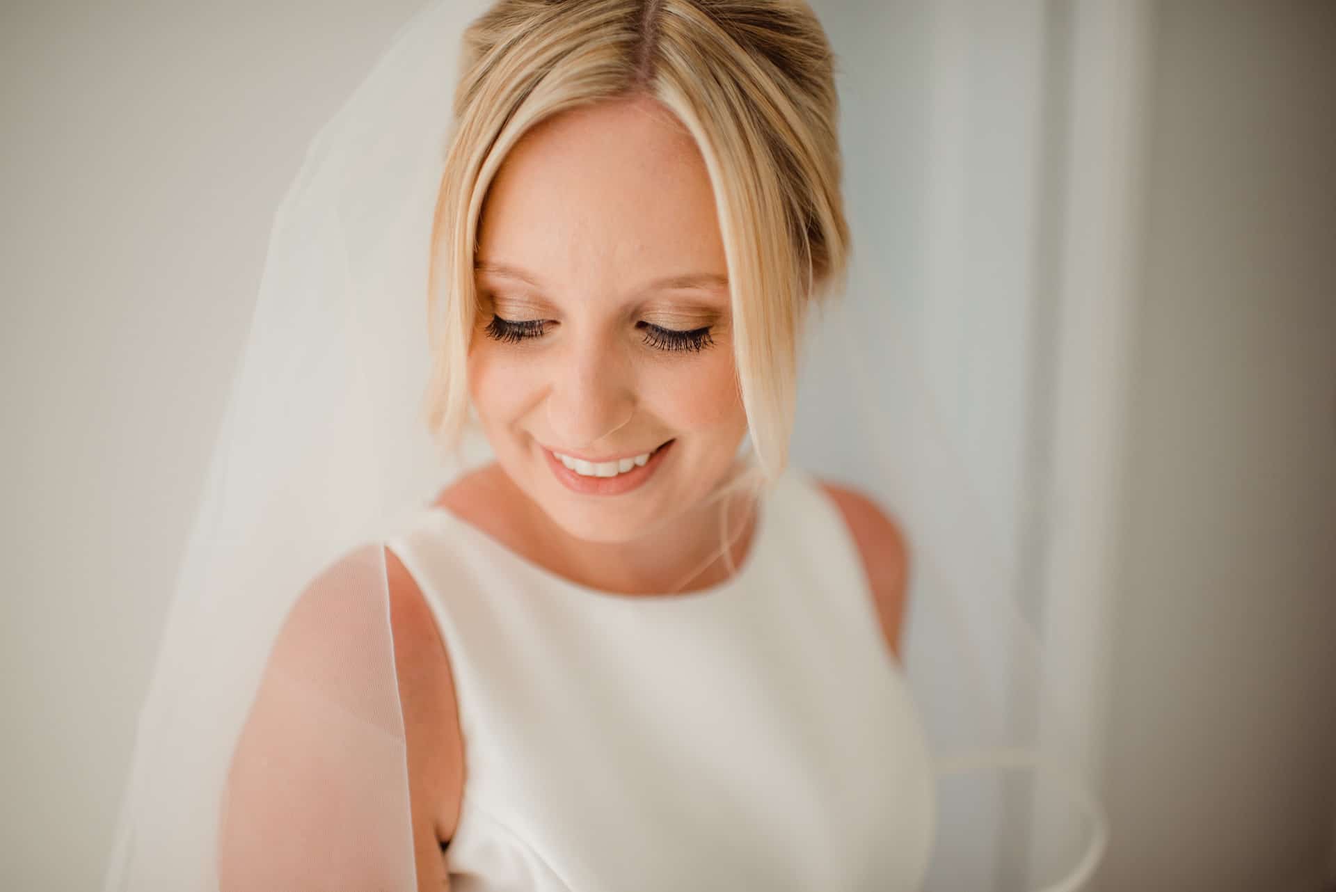 smiling bride taking picture in white background