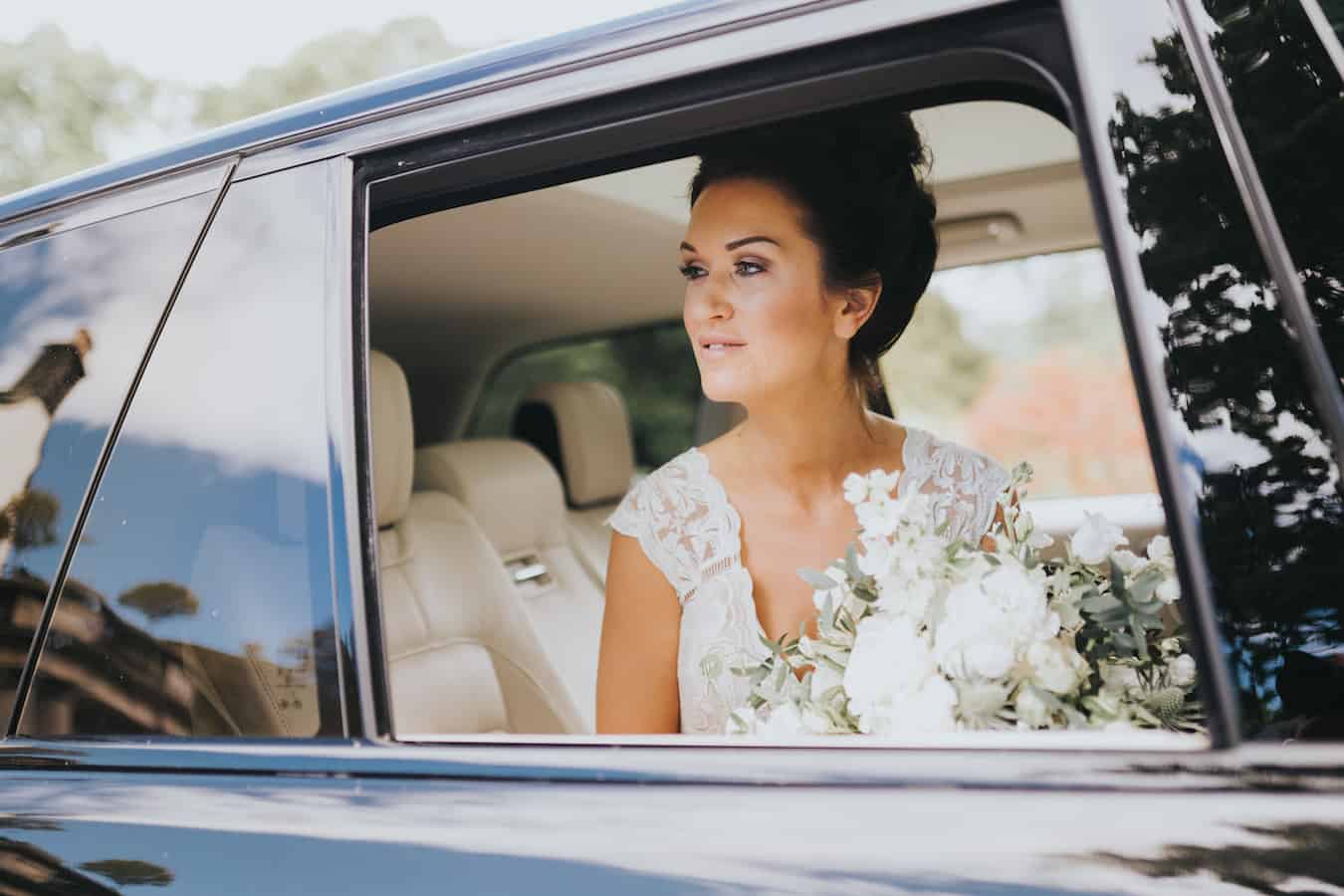 a bride looking out the window of a car